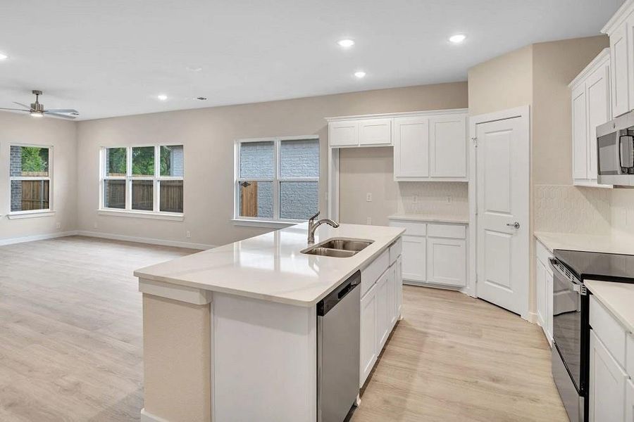 Kitchen featuring appliances with stainless steel finishes, light wood-style flooring, a ceiling fan, recessed lighting, and backsplash Kitchen featuring appliances with stainless steel finishes, light wood-style flooring, a ceiling fan, recessed lighting, and backsplash