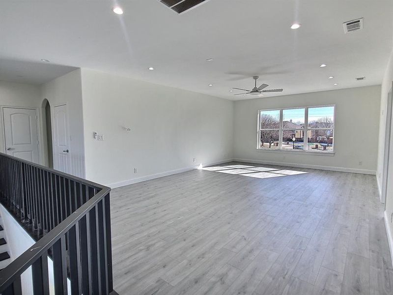 Unfurnished room with ceiling fan and light wood-type flooring