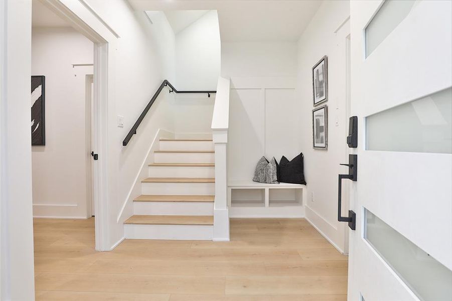 Welcome to streamlined elegance with this practical mudroom, featuring a chic bench area to neatly store footwear and accessories. Flanked by the convenience of a direct garage access to your right and an inviting guest suite to your left, this entryway perfectly marries functionality with style.