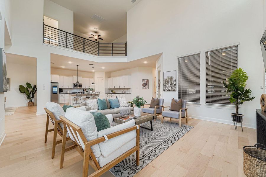 Living area featuring light wood finished floors, a towering ceiling, ceiling fan, and recessed lighting Living area featuring light wood finished floors, a towering ceiling, ceiling fan, and recessed lighting