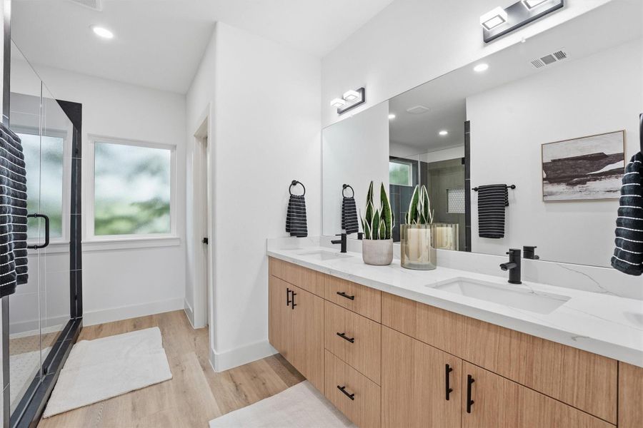 Primary bath with quartz counters, double vanity, and upgraded LED lighting.
