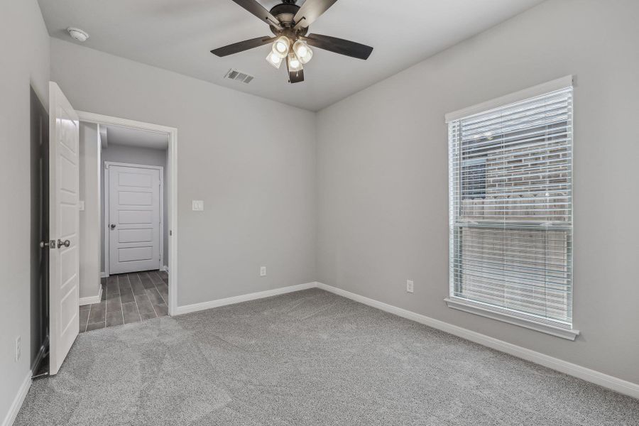 Spare room featuring carpet floors, a ceiling fan, baseboards, and a smoke detector Spare room featuring carpet floors, a ceiling fan, baseboards, and a smoke detector