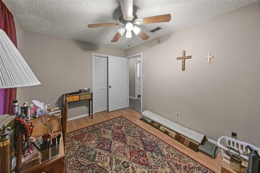 Office area featuring a ceiling fan, wood finished floors, and a textured ceiling