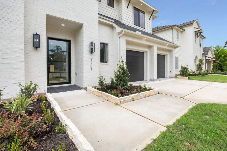 Clean lines, modern lighting, and a striking black-framed front door set the tone for the elevated design found throughout this newly built home. Clean lines, modern lighting, and a striking black-framed front door set the tone for the elevated design found throughout this newly built home.