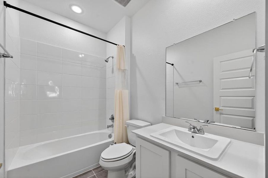 Contemporary bathroom featuring a combined shower and tub with white subway tile surround, a single vanity with an integrated sink, polished chrome faucet, and an expansive wall-mounted mirror