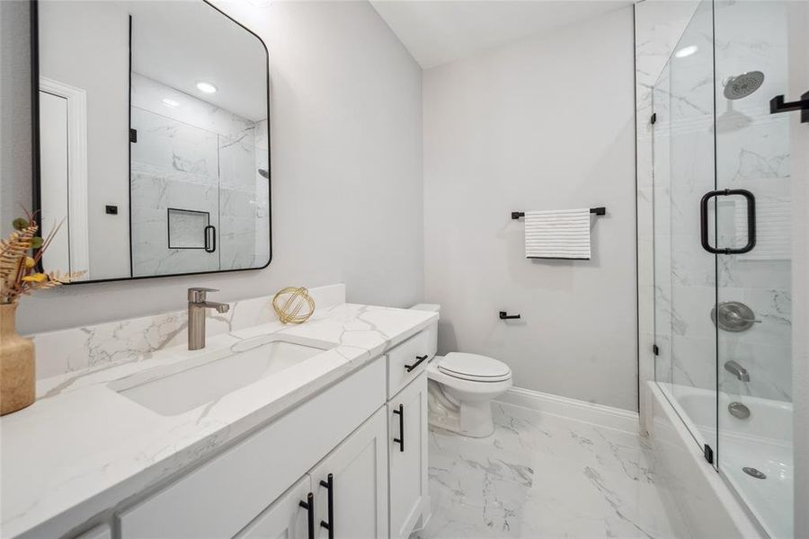Modern bathroom featuring a white vanity with integrated sink, quartz countertop, and brushed nickel faucet
