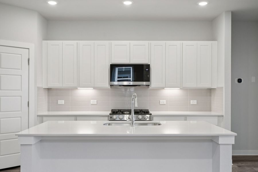 A kitchen with white cabinets.