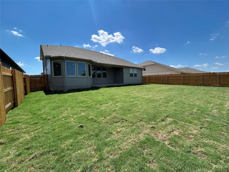 Back of property with a fenced backyard, a patio area, and a shingled roof Back of property with a fenced backyard, a patio area, and a shingled roof