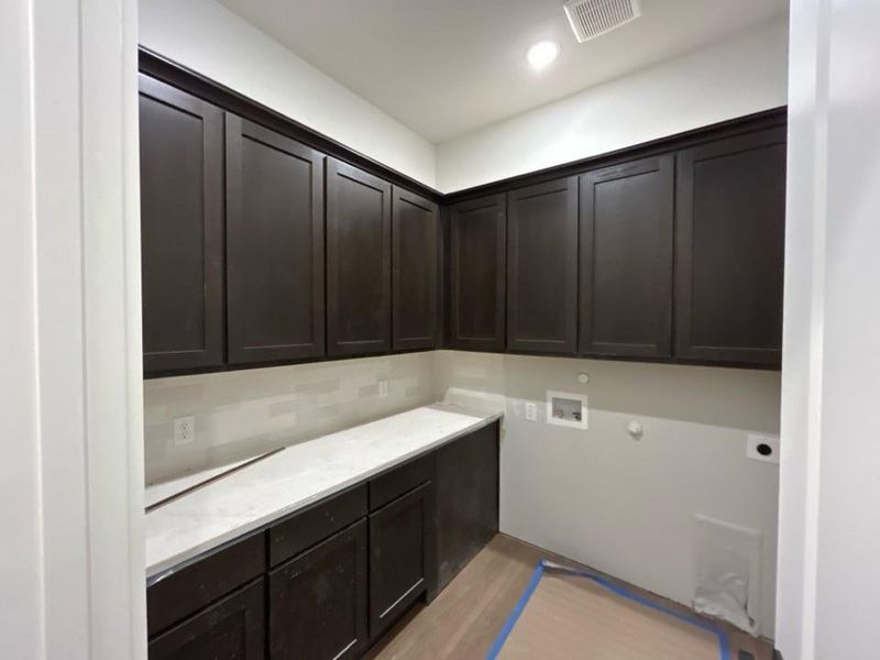 Laundry area featuring gas dryer hookup, cabinet space, washer hookup, light wood-style flooring, and recessed lighting