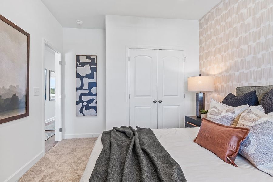 A bedroom with a bed and a lamp.