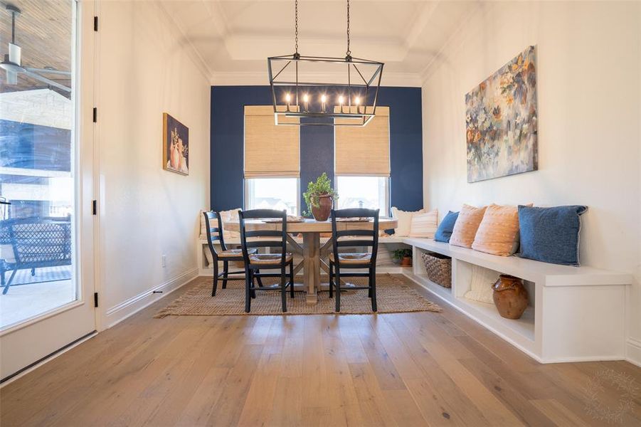 Dining room with light wood-style floors and suspended lighting Dining room with light wood-style floors and suspended lighting