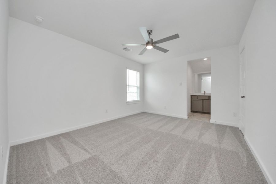 Secondary bedroom features plush carpeting, large windows that let in plenty of natural light, bright paint, and spacious closets. Sample photo of completed home with similar floor plan. Actual colors and selections may vary.