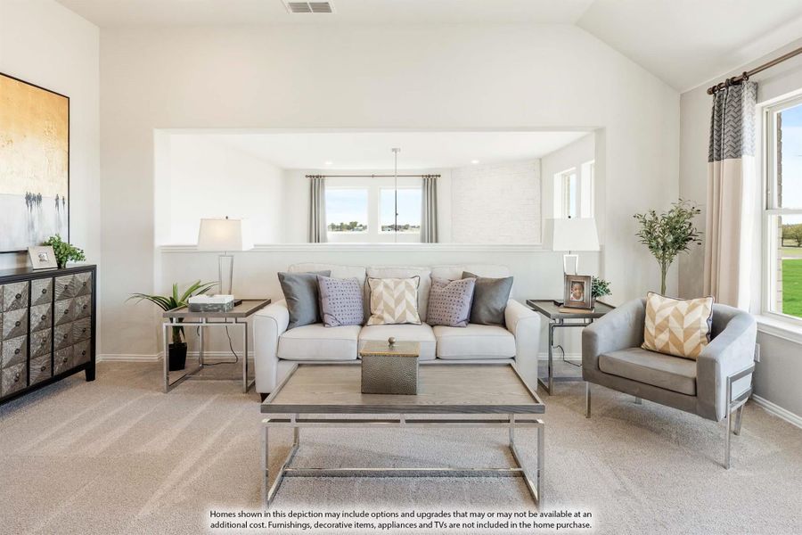 Living room with light gray sofa, accent chair, wood coffee table, and vaulted ceiling with large windows