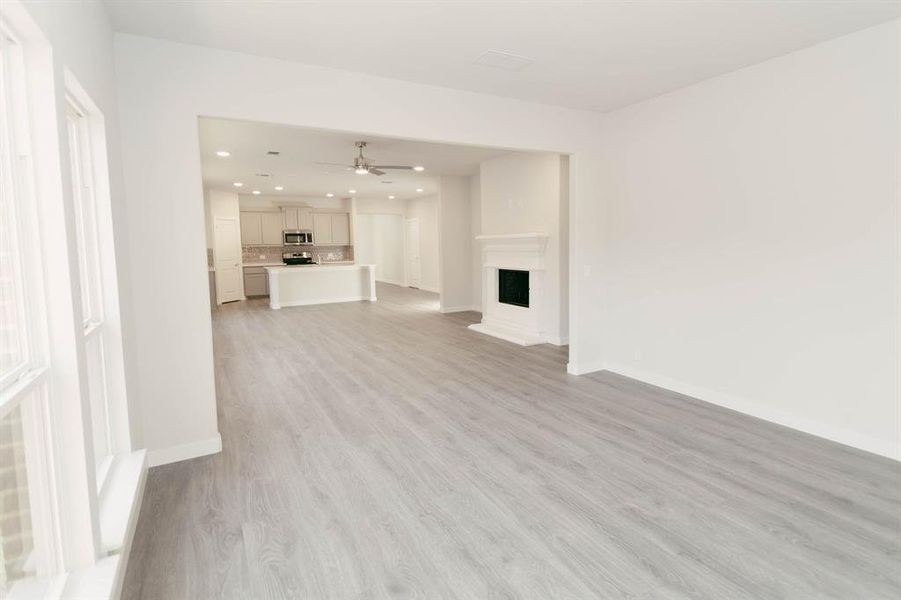 Unfurnished living room with ceiling fan and light hardwood / wood-style floors