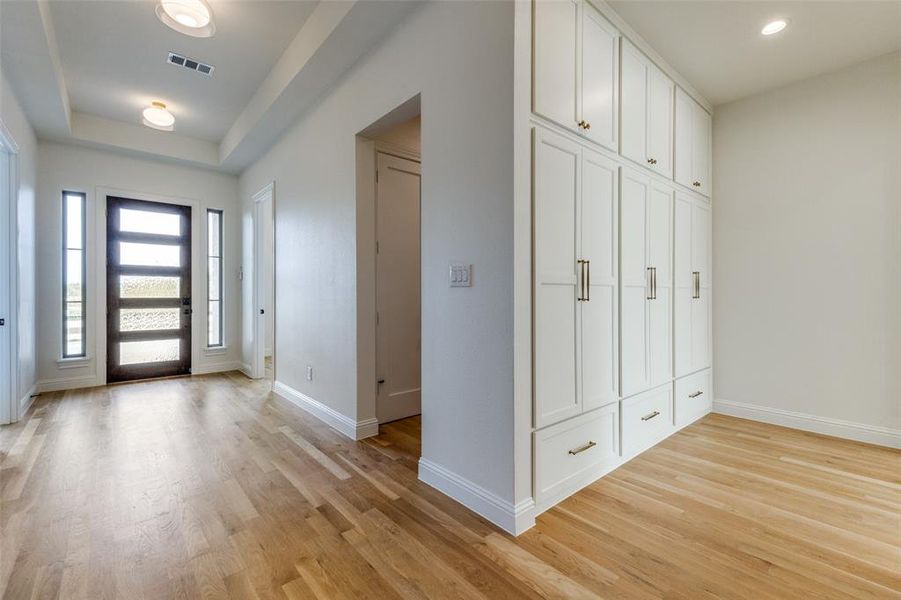 Entryway featuring baseboards, light wood-style flooring, recessed lighting, and a raised ceiling