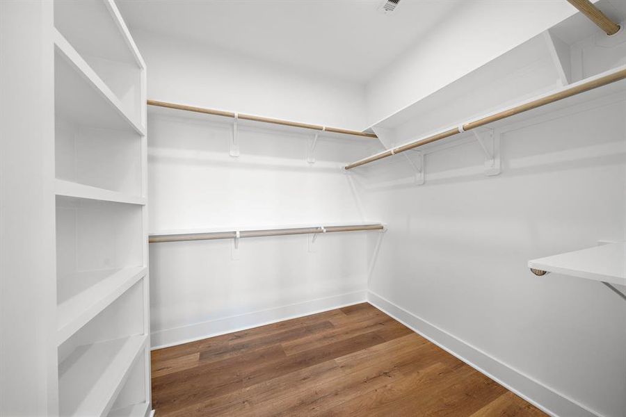 Spacious walk-in closet with ample shelving and hanging space, ideal for organized living.