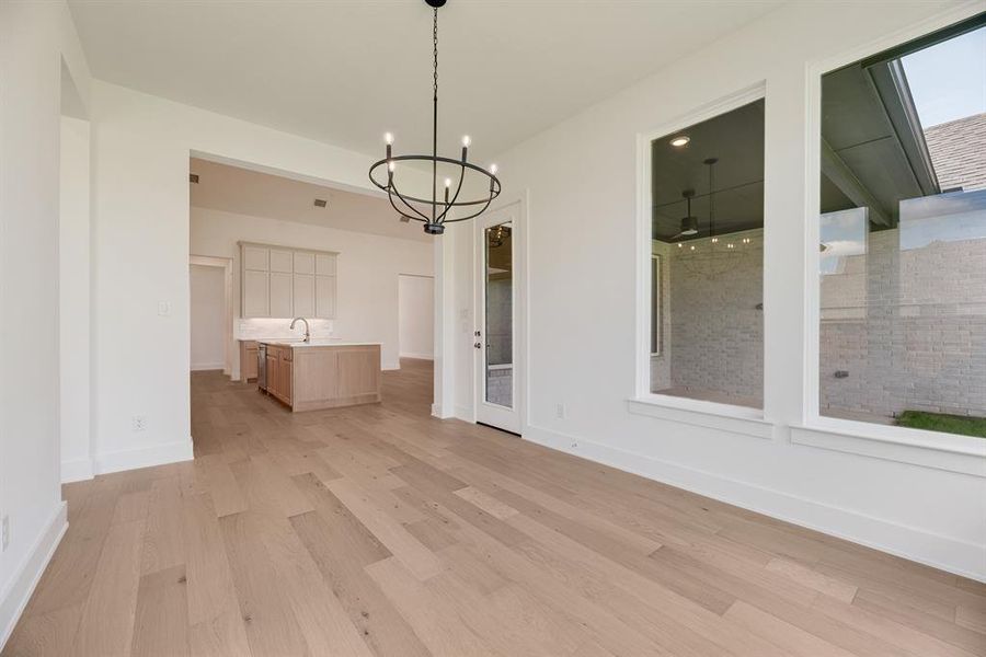 Unfurnished dining area with light wood-type flooring and a chandelier