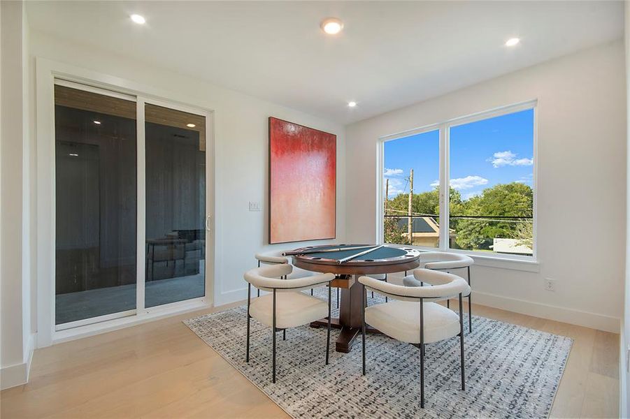 Dining room with light wood-style floors and recessed lighting Dining room with light wood-style floors and recessed lighting