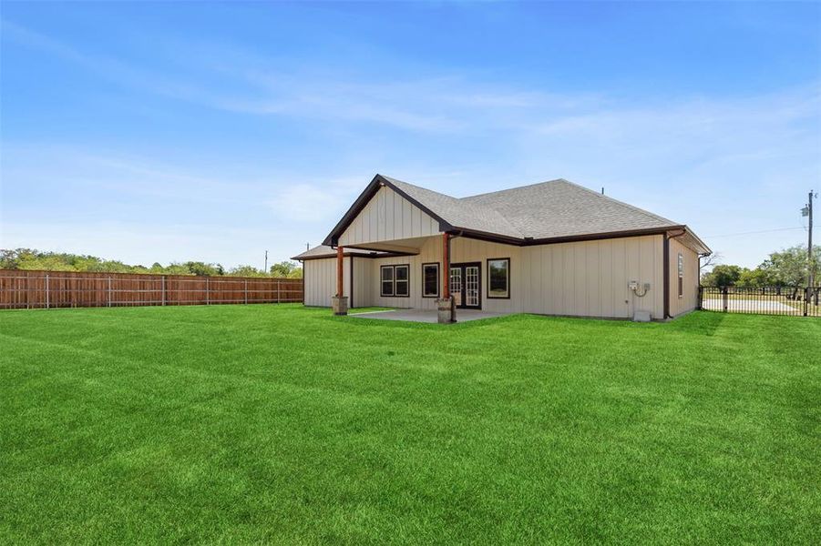 Back of house featuring a lawn and a patio