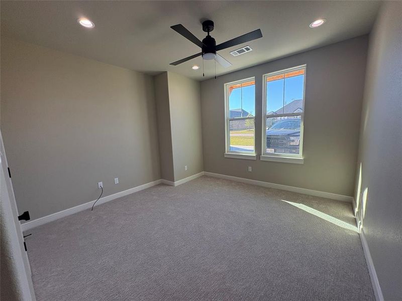 Carpeted empty room with ceiling fan and recessed lighting