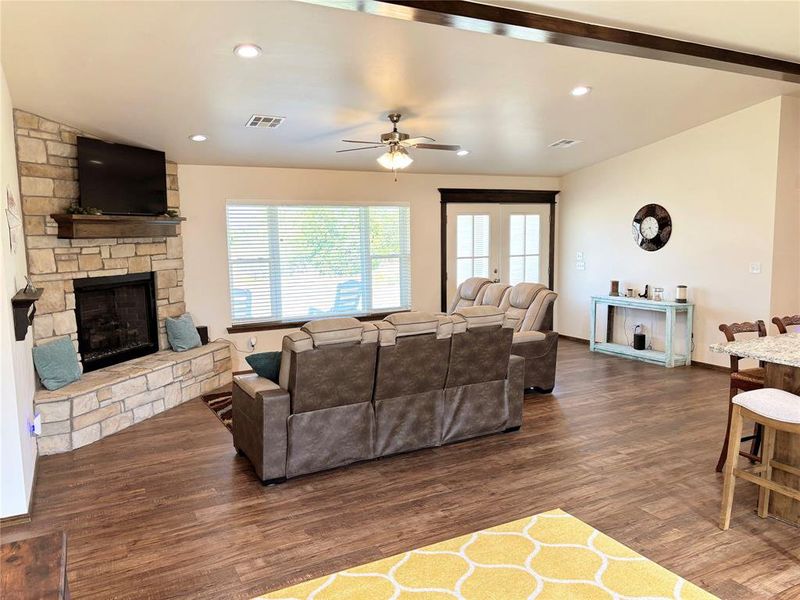 Living area featuring a stone fireplace, a ceiling fan, and recessed lighting Living area featuring a stone fireplace, a ceiling fan, and recessed lighting