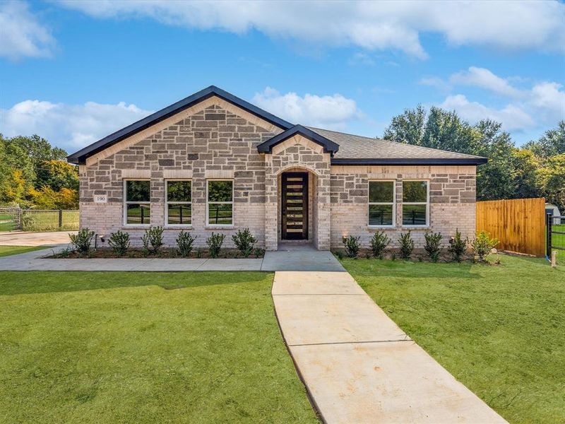 View of front facade featuring brick siding and stone siding