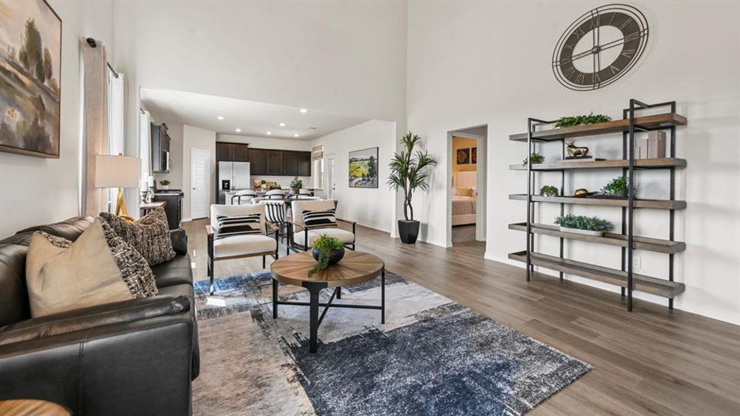 Living room featuring a towering ceiling and dark wood-style flooring Living room featuring a towering ceiling and dark wood-style flooring