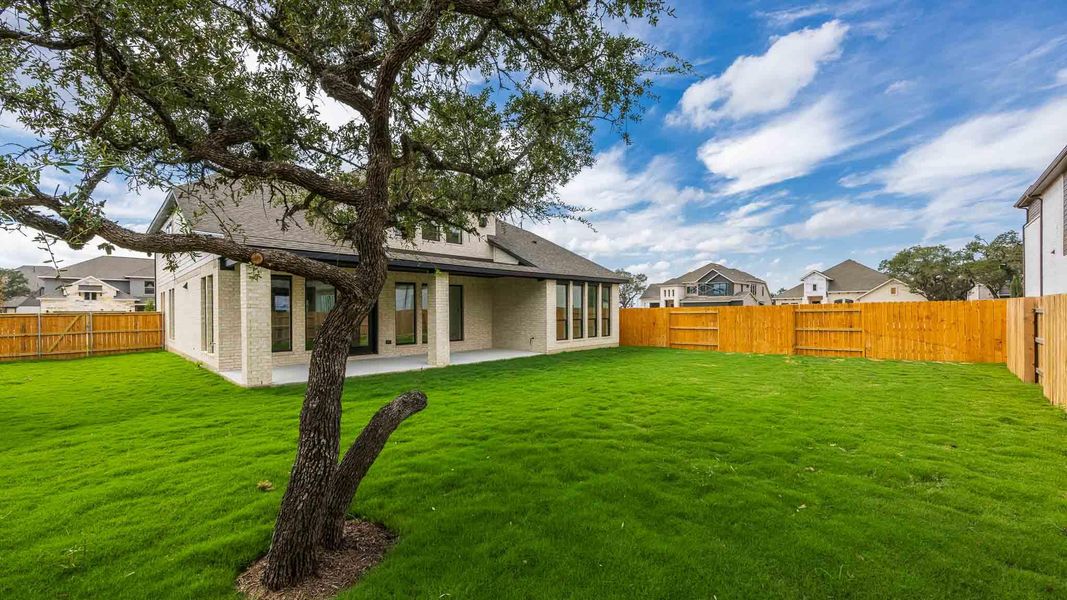 Back of property with a patio area, a fenced backyard, brick siding, and roof with shingles