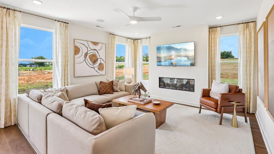 Gathering room with ceiling fan, windows, and fireplace