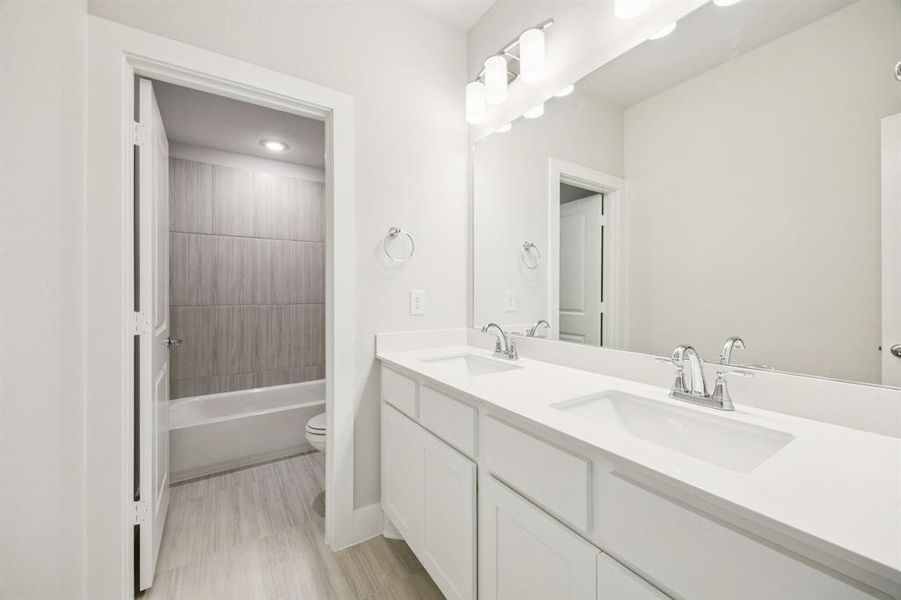 Bathroom with double vanity and shower / tub combination