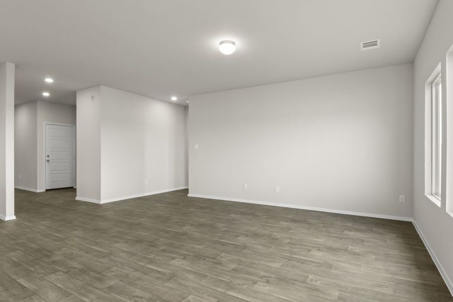 Image of a one story home living room with dark wood-like flooring and light grey walls