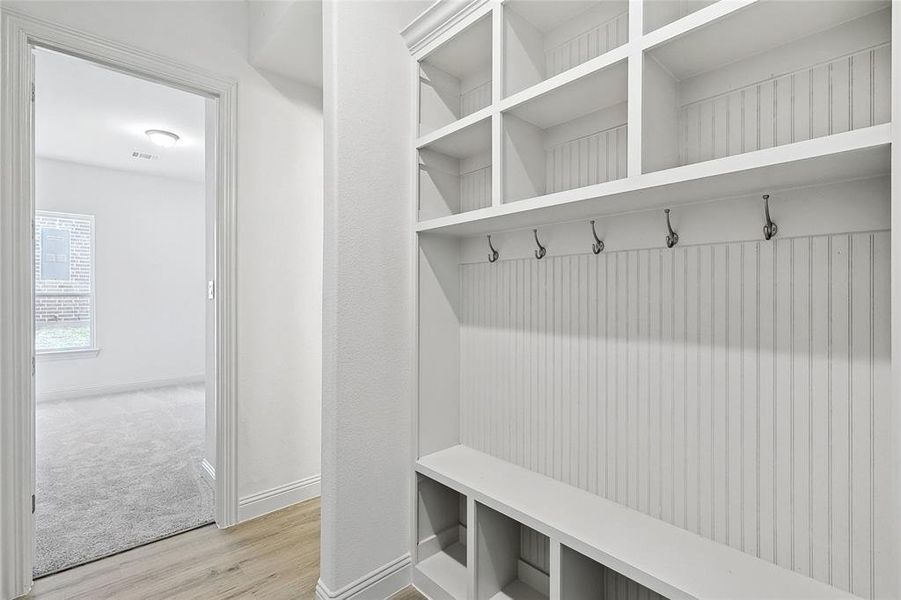Mudroom featuring light wood-style flooring and baseboards