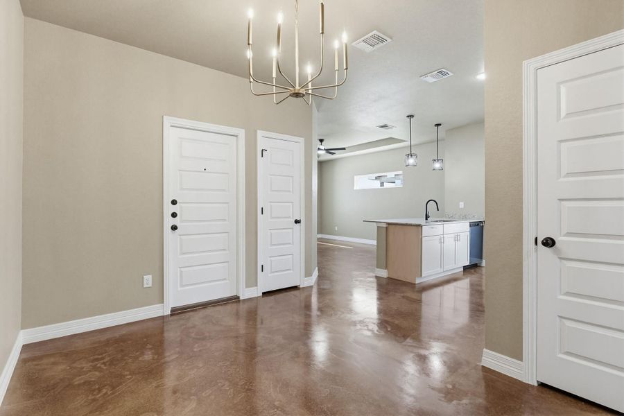 Unfurnished dining area featuring finished concrete floors and hanging lights
