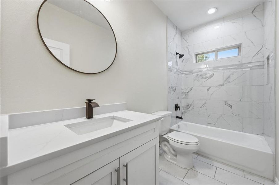 Full bathroom featuring tub / shower combination, vanity, and light tile patterned flooring Full bathroom featuring tub / shower combination, vanity, and light tile patterned flooring