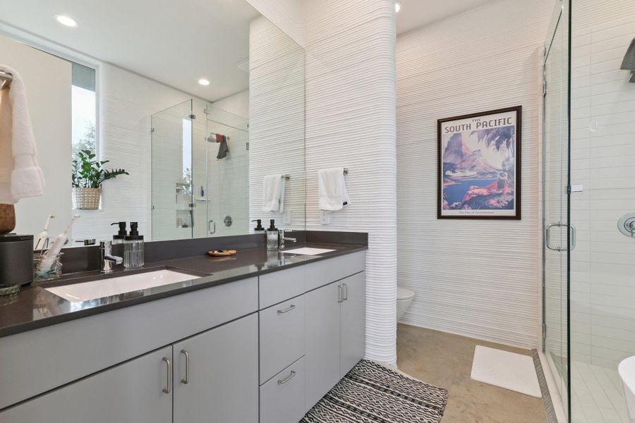 Bathroom with double vanity, a stall shower, and recessed lighting