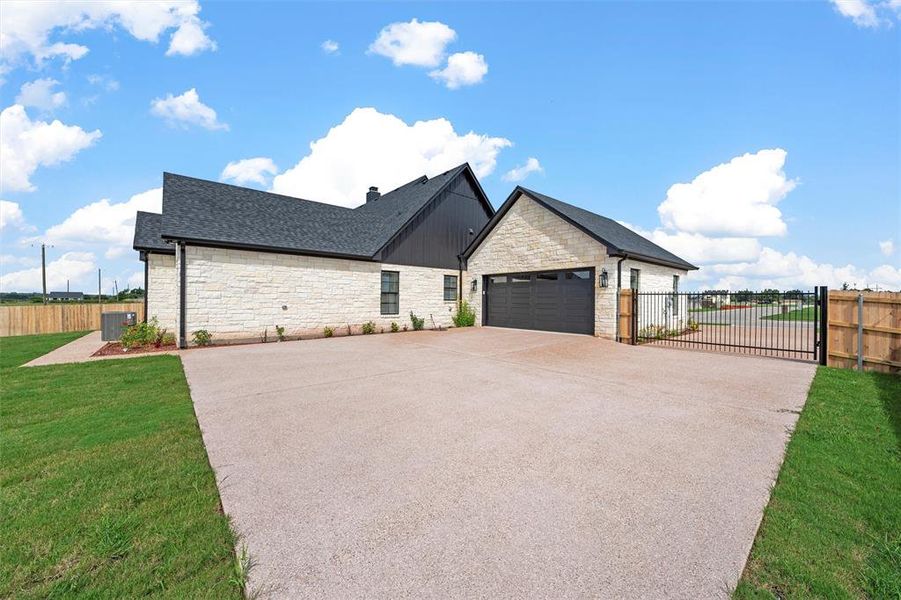 View of front of house featuring stone siding, concrete driveway, roof with shingles, a gate, and an attached garage View of front of house featuring stone siding, concrete driveway, roof with shingles, a gate, and an attached garage