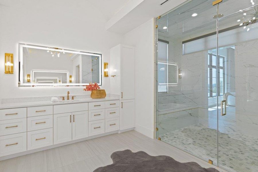 Luxurious primary bath with a spacious vanity, walk-in shower, and elegant tile flooring.