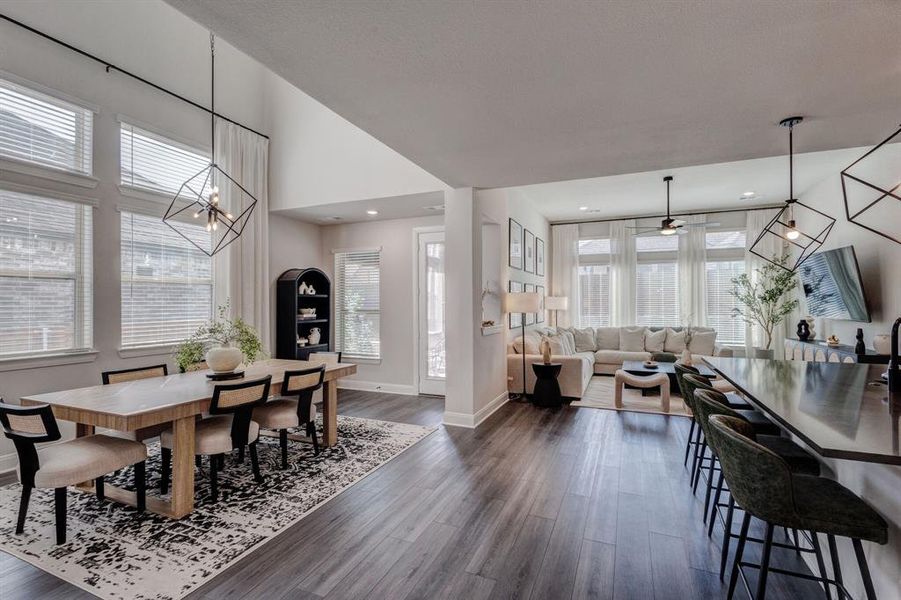Dining room with a chandelier, dark wood-type flooring, a high ceiling, and a ceiling fan