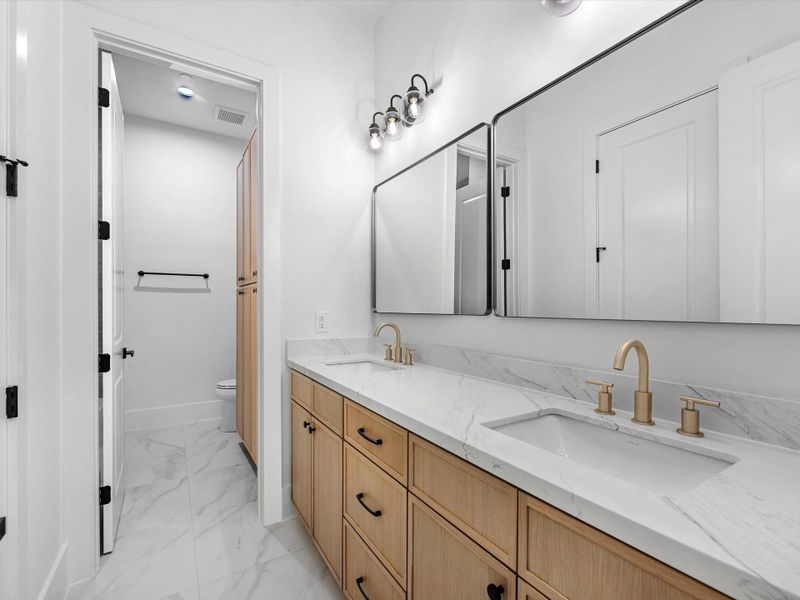 Bathrooms are thoughtfully designed with double sinks, expansive counter space, and additional built-ins for maximum functionality.
