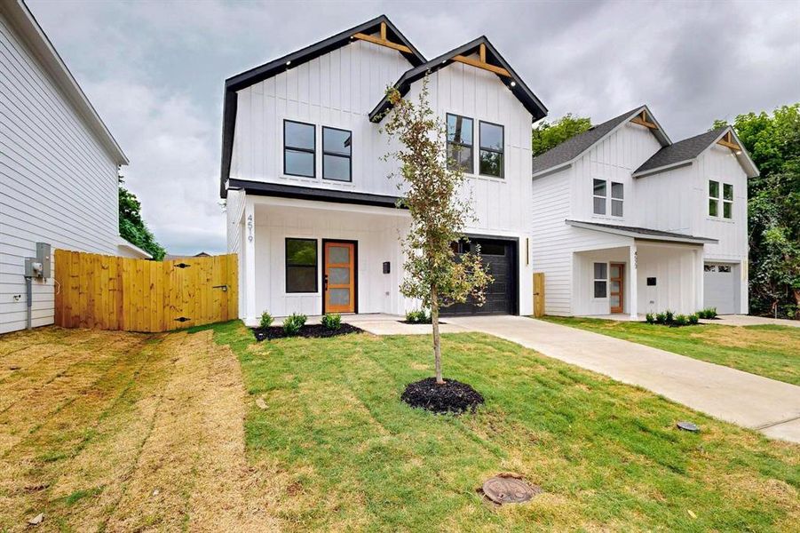 Modern farmhouse featuring board and batten siding, an attached garage, concrete driveway, and a gate Modern farmhouse featuring board and batten siding, an attached garage, concrete driveway, and a gate
