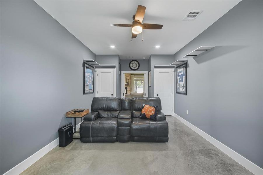 Living area featuring concrete flooring, ceiling fan, and recessed lighting Living area featuring concrete flooring, ceiling fan, and recessed lighting