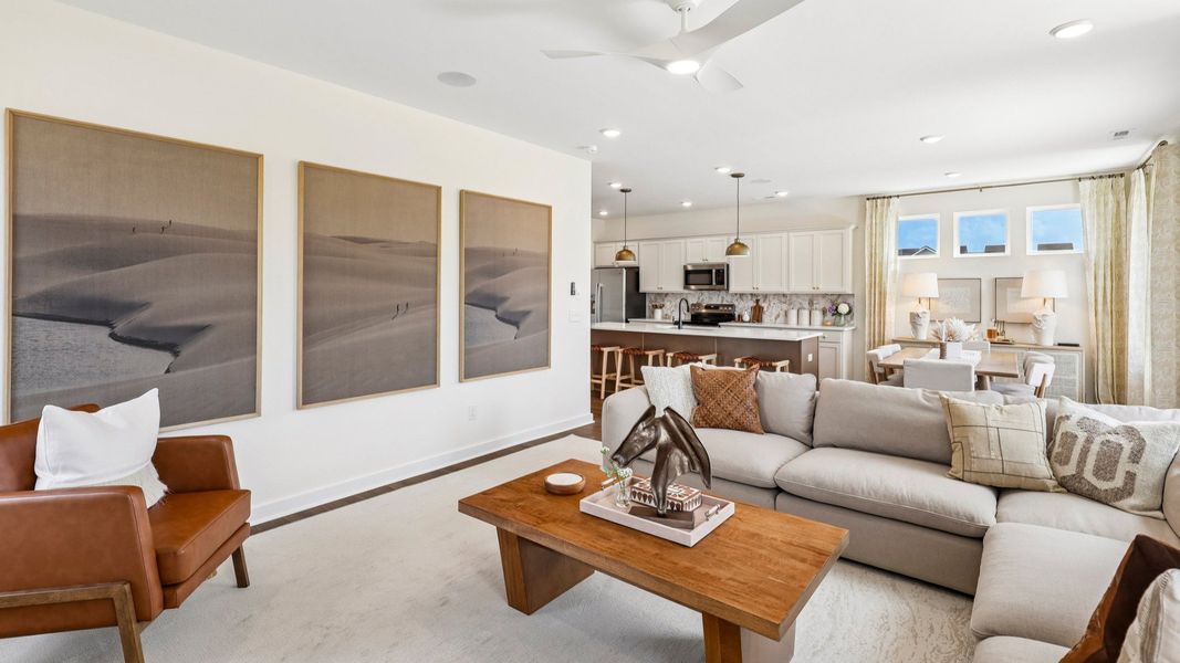 Gathering room with ceiling fan, hard surface flooring, fireplace, and natural lighting from windows Gathering room with ceiling fan, hard surface flooring, fireplace, and natural lighting from windows