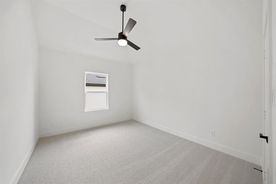 Carpeted empty room with lofted ceiling and ceiling fan Carpeted empty room with lofted ceiling and ceiling fan