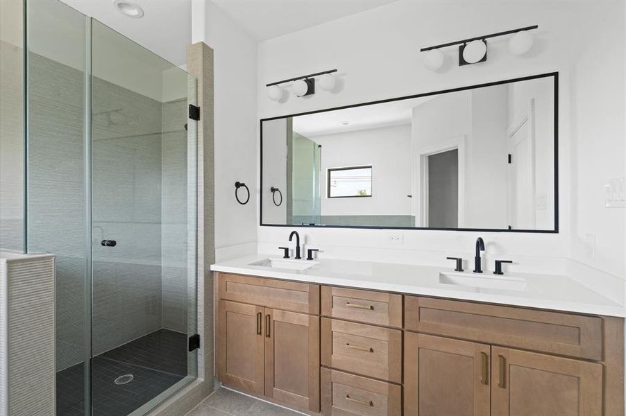 Elegant primary ensuite bathroom with dual vanities and an elongated mirror with the perfect lighting.