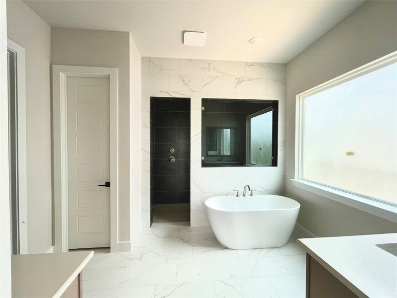 Luxurious bathroom features a sleek freestanding tub, a spacious walk-in shower, and ample counter space. Luxurious bathroom features a sleek freestanding tub, a spacious walk-in shower, and ample counter space.