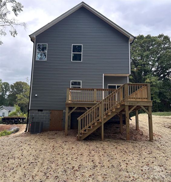 Rear view.  Large deck with steps to grade.