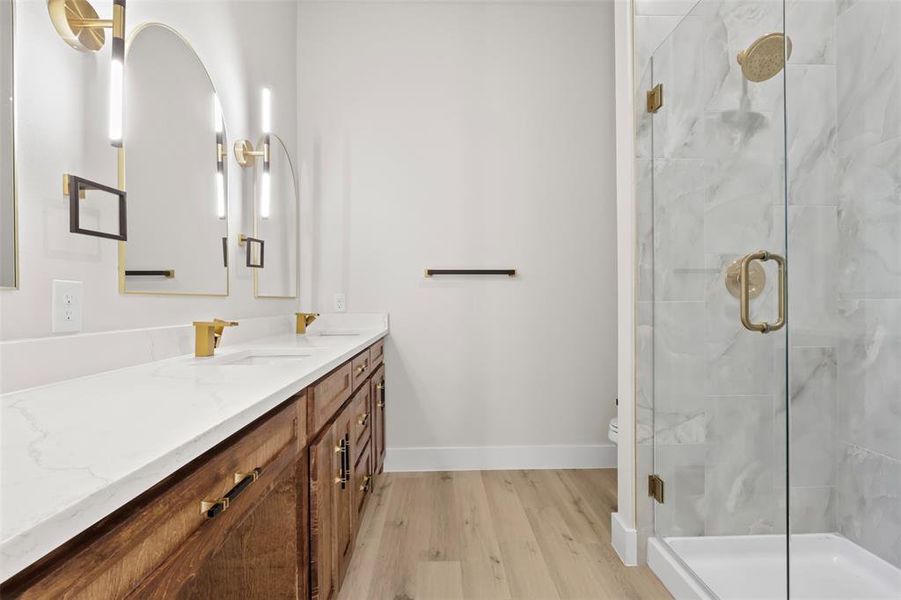 Bathroom with a shower with shower door, toilet, wood-type flooring, and vanity