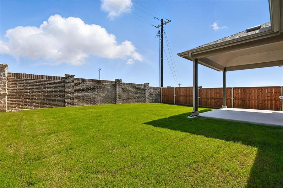 Fenced backyard with a patio area Fenced backyard with a patio area