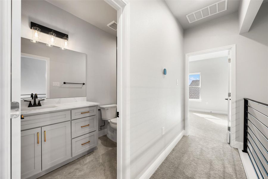 Bathroom with vanity and light carpet