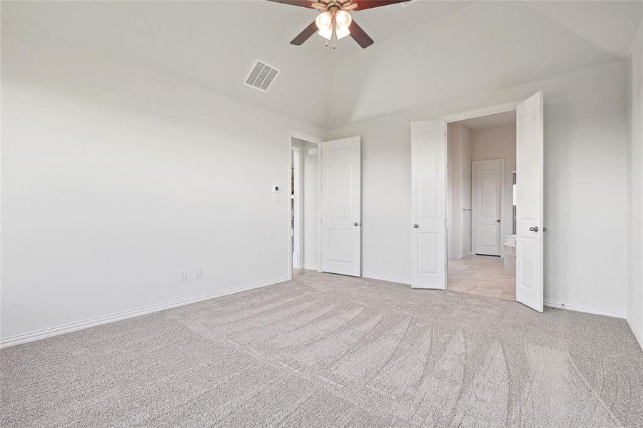 Unfurnished bedroom with ceiling fan, light carpet, and high vaulted ceiling